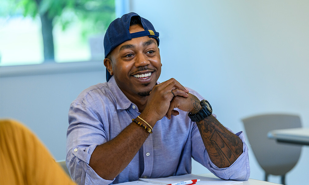 Student smiling, sitting in classroom